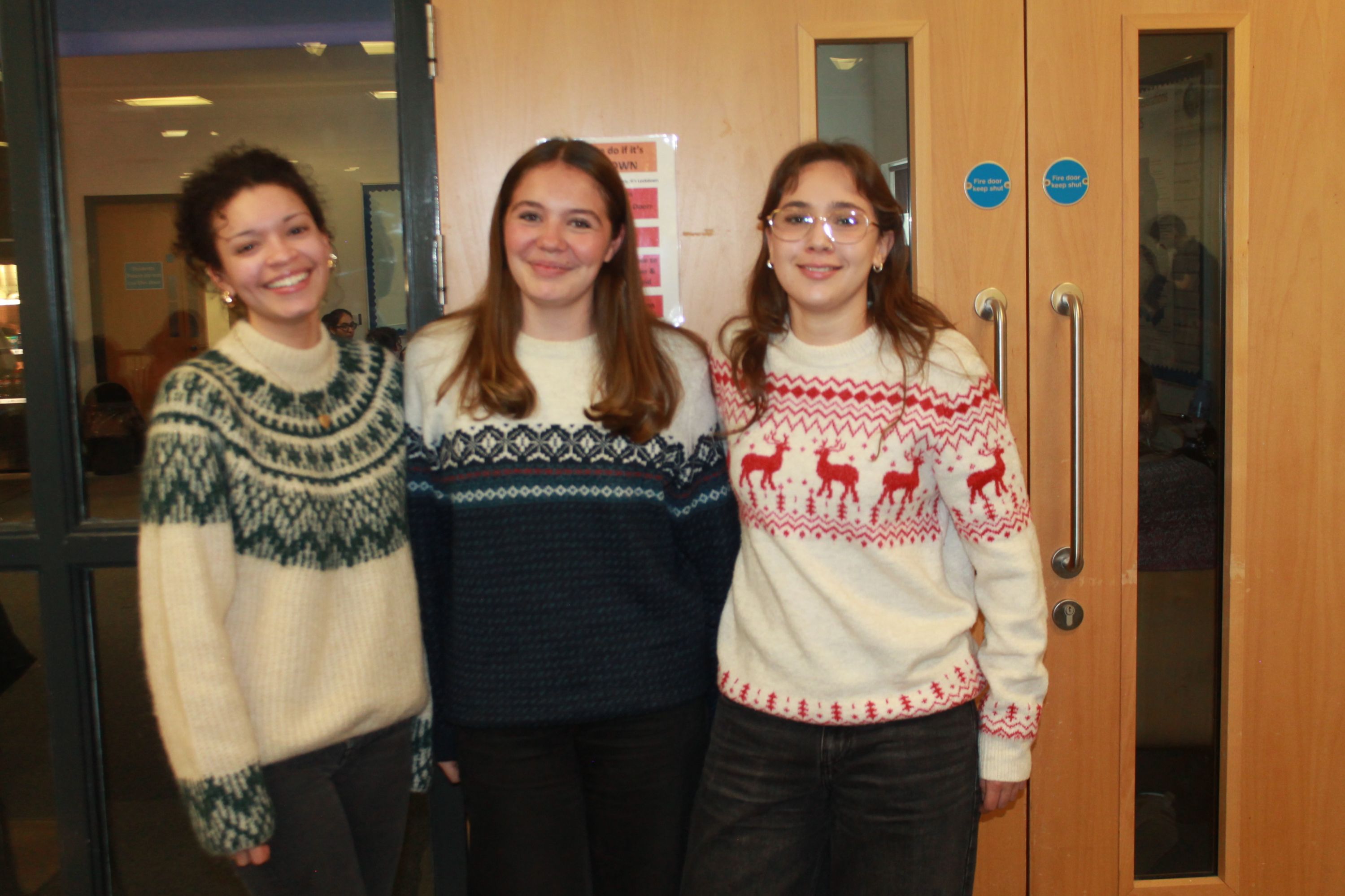 three students posing in their Christmas Jumpers