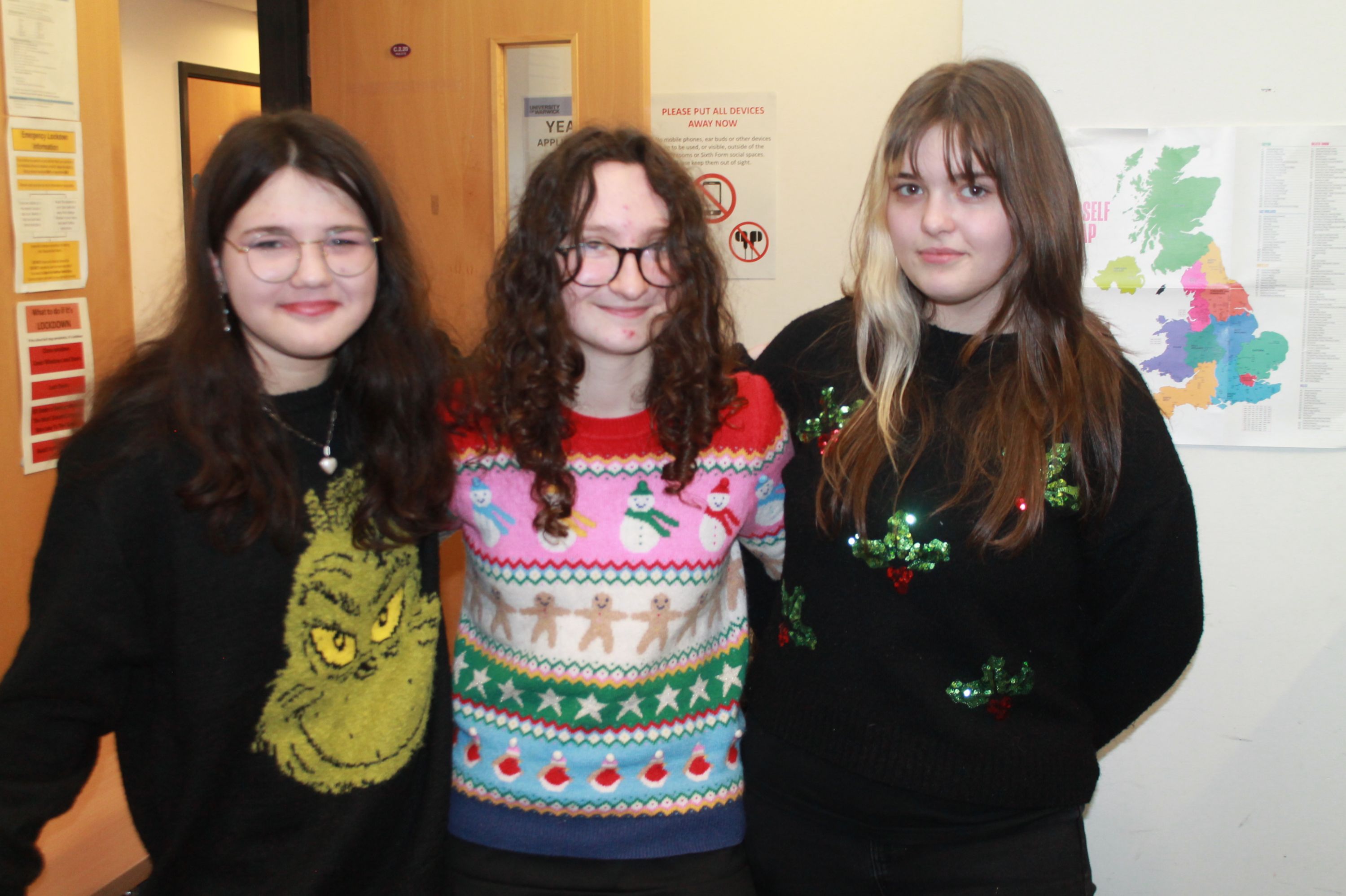 three students posing in Christmas Jumpers