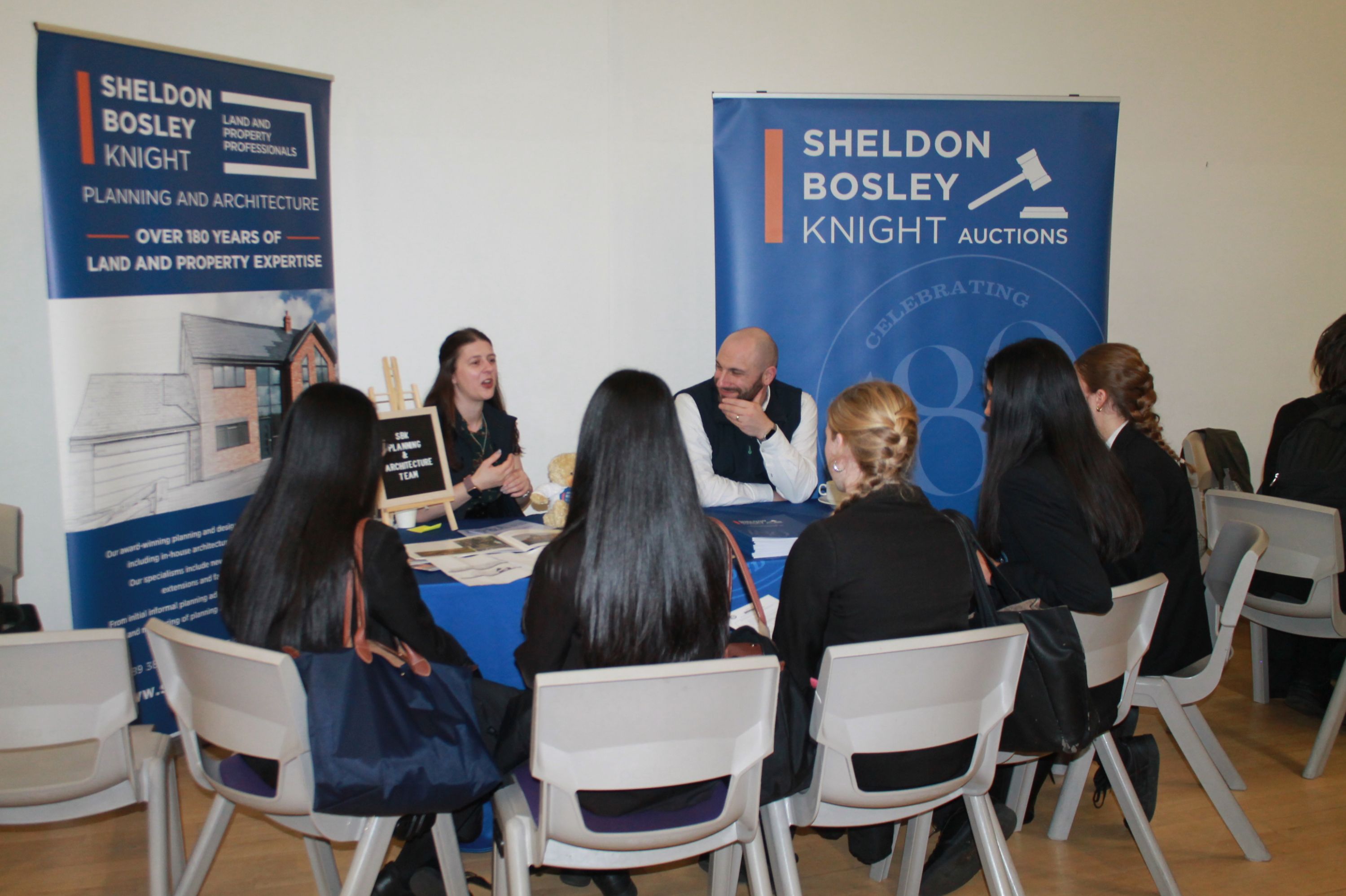 A group of five students  sitting at a table