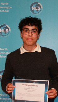 a young man holding a certificate in front of a blue backdro
