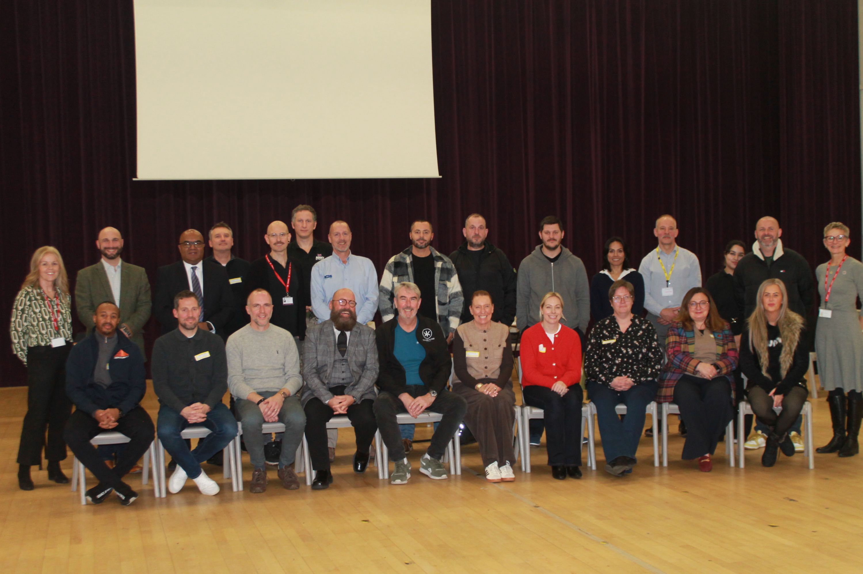 23 people sitting on chairs in the theatre