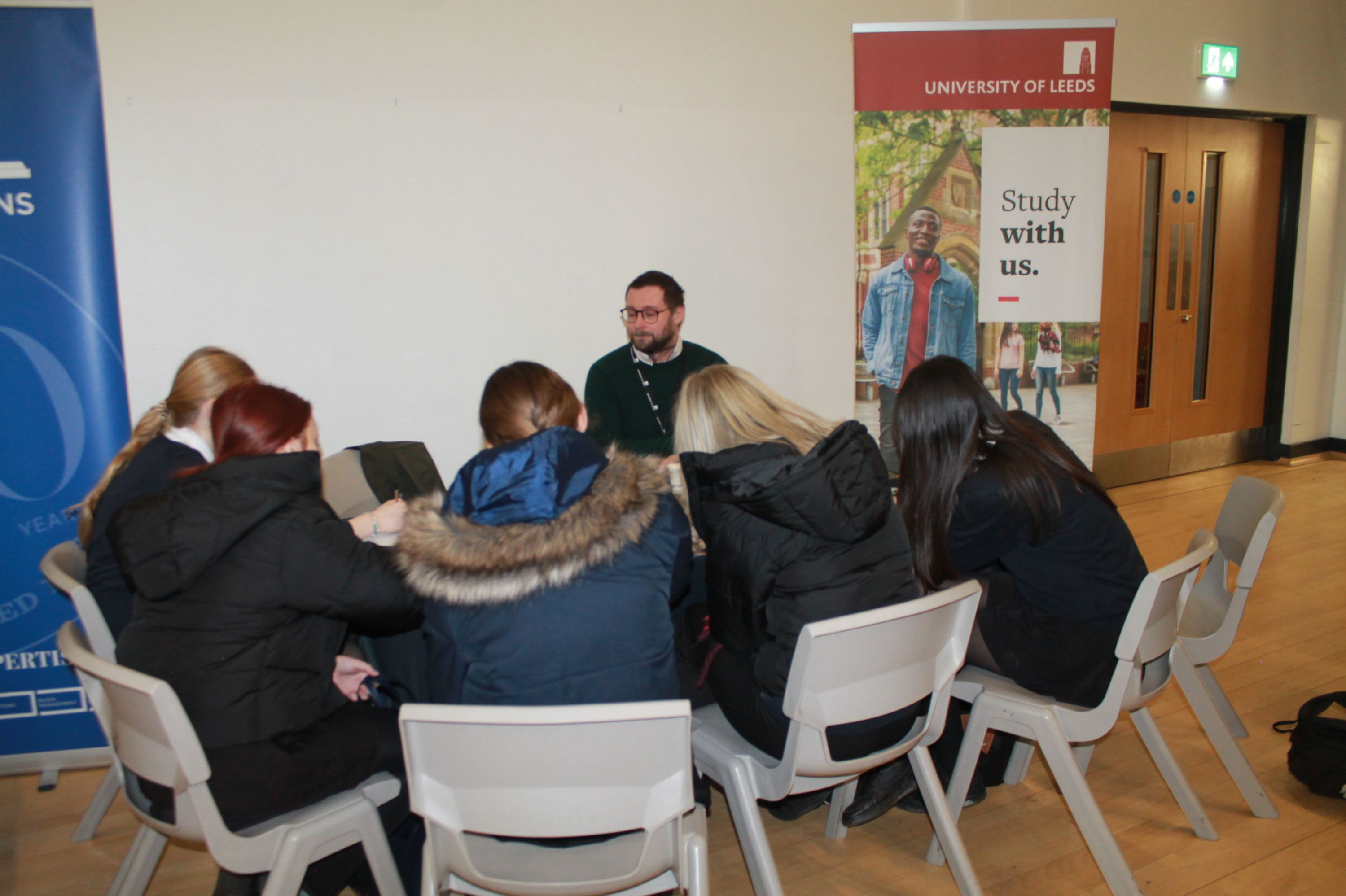 A group of five students  sitting at a table