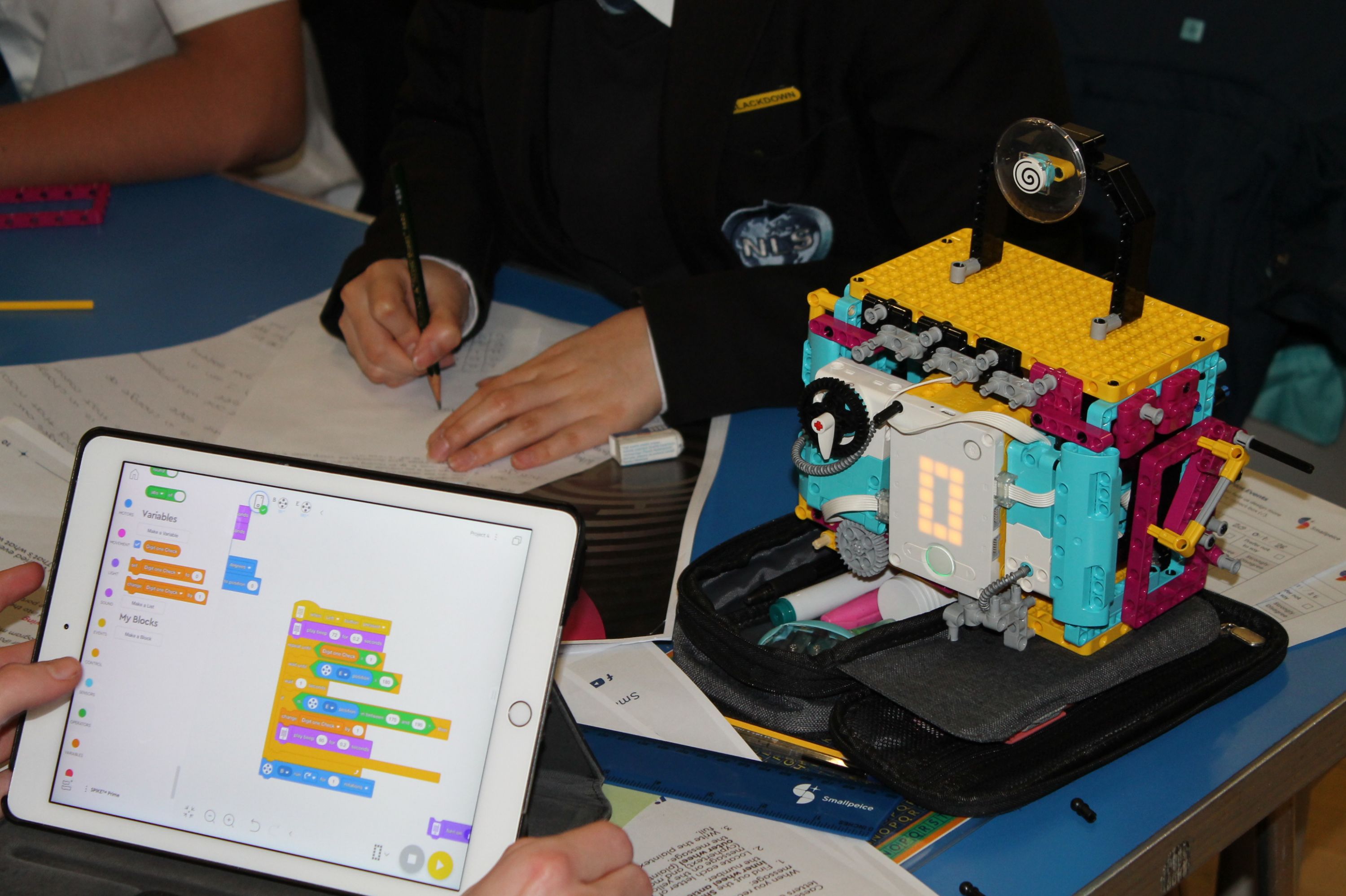 an ipad screen, a model and a person writing