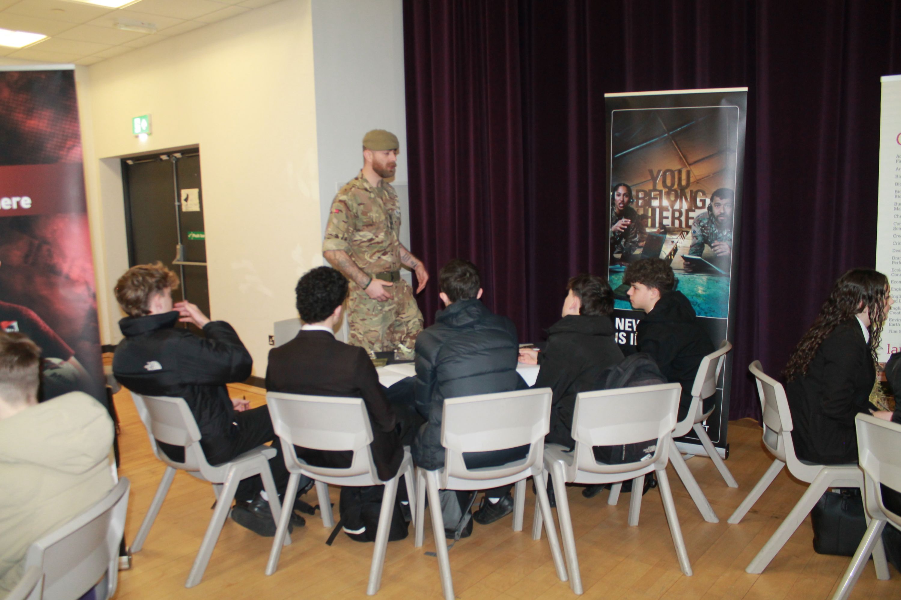 A group of five students  sitting at a table