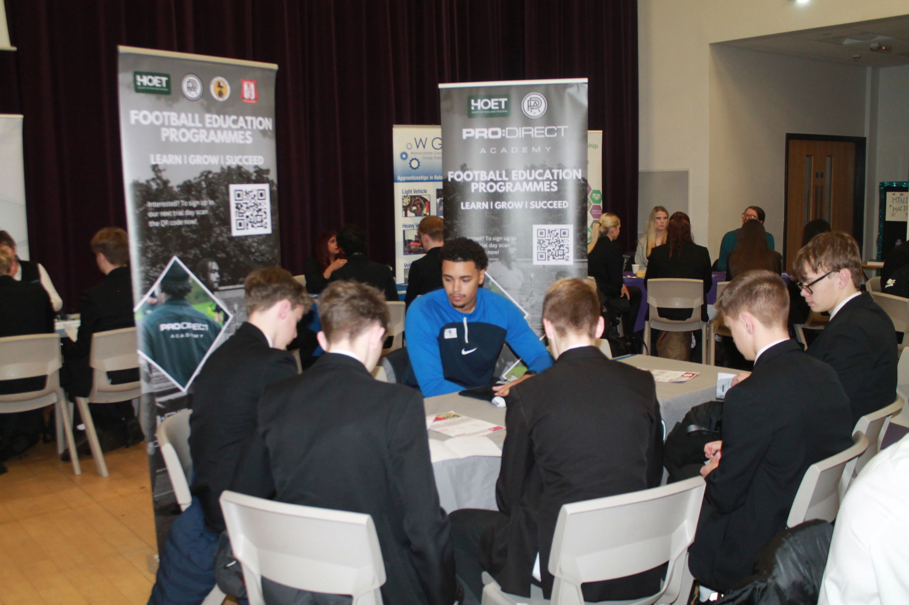 A group of five students  sitting at a table