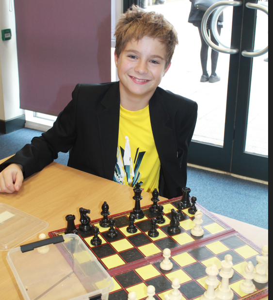 a student playing chess wearing a yellow top