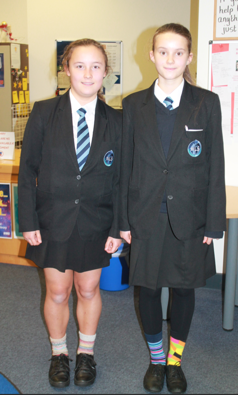 two students wearing their NLS uniform and odd coloured socks