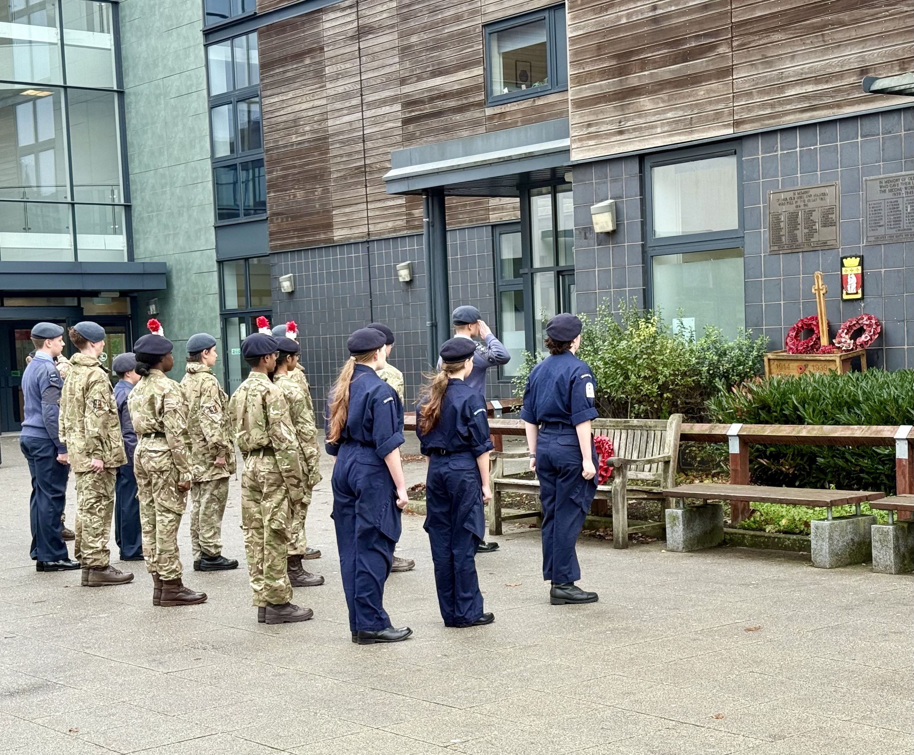 students in cadet uniforms laying a wreath  