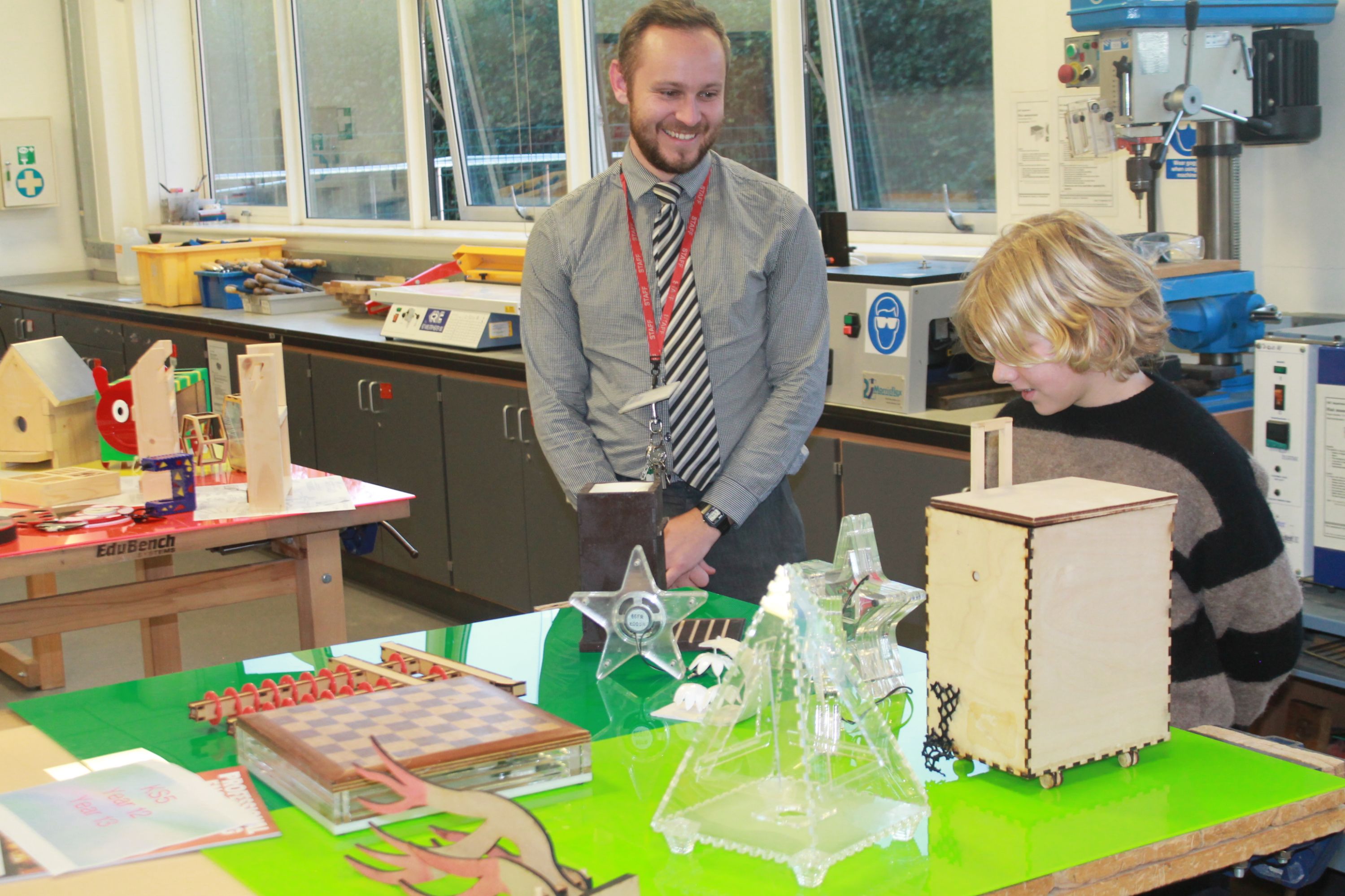 a teacher talking to a visitor about items made in Design Technology