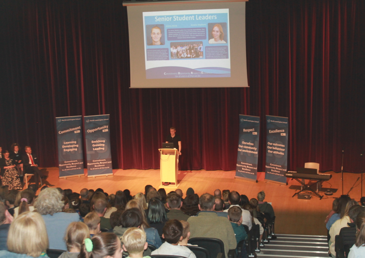SSL Jimmy talking at a lecturn in the theatre about his  experiences