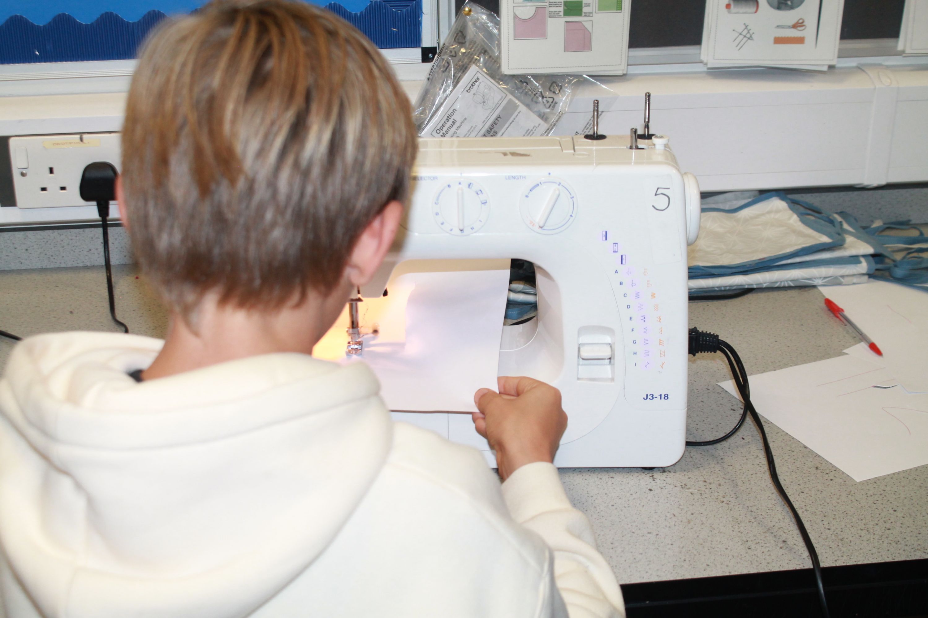 a boy trying a sewing machine