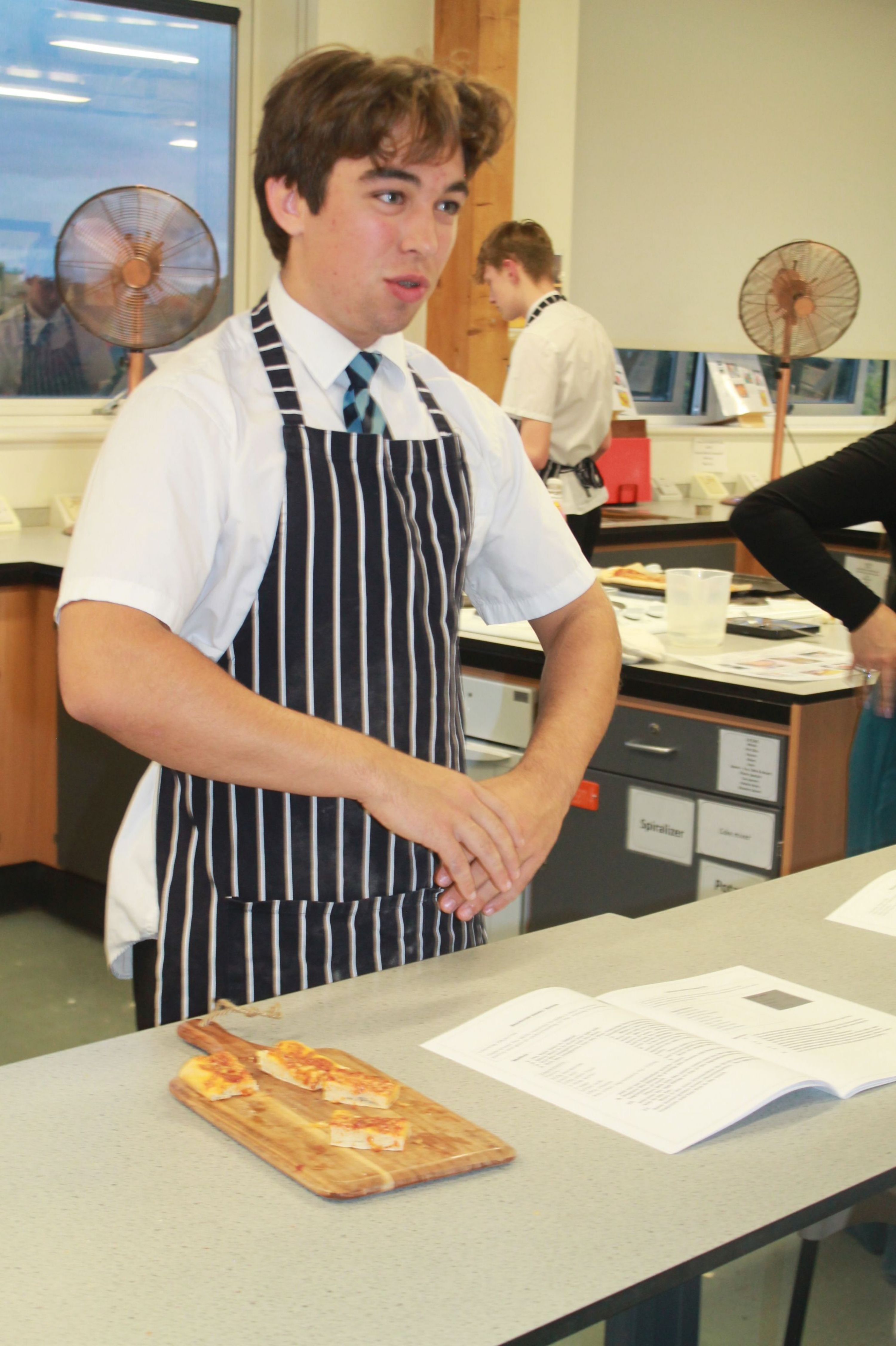a studnets talking about food technology and pizza samples on a board